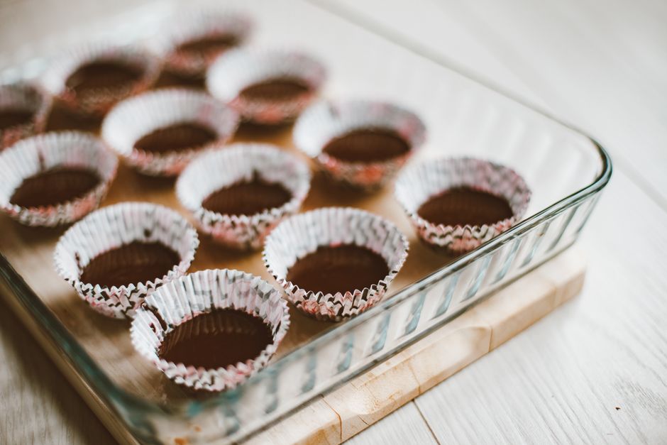 Glass dish with empty muffin liners ready for baking. Ideal for food preparation concepts.